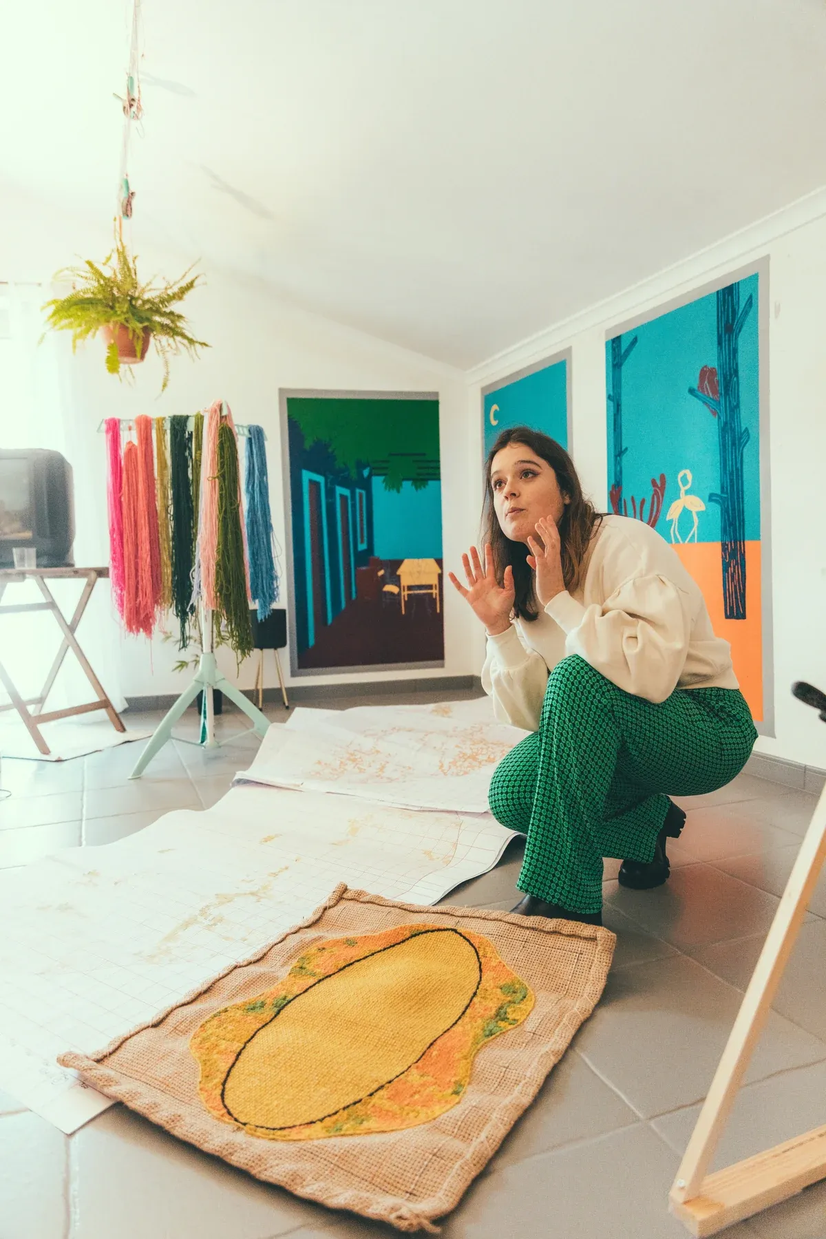 Susana Cereja no estúdio junto a uma obra têxtil em ponto de Arraiolos, fotografada para a PRIMA Magazine.