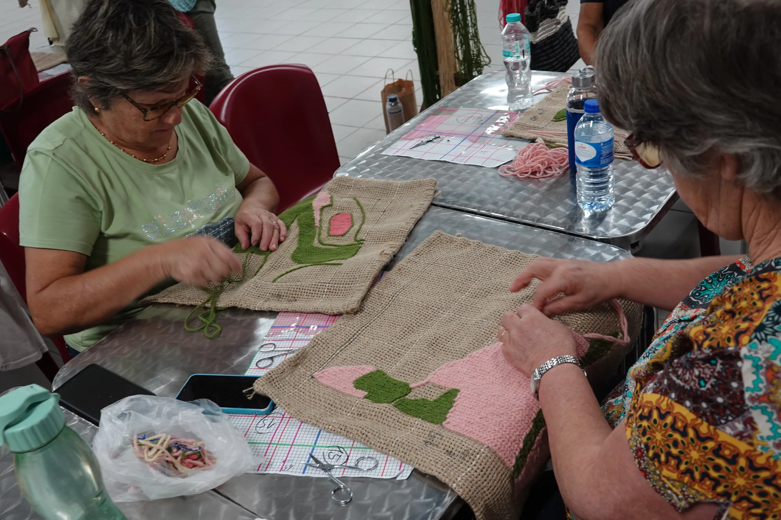 Participants working on individual textile modules in green and pink during the residency.
