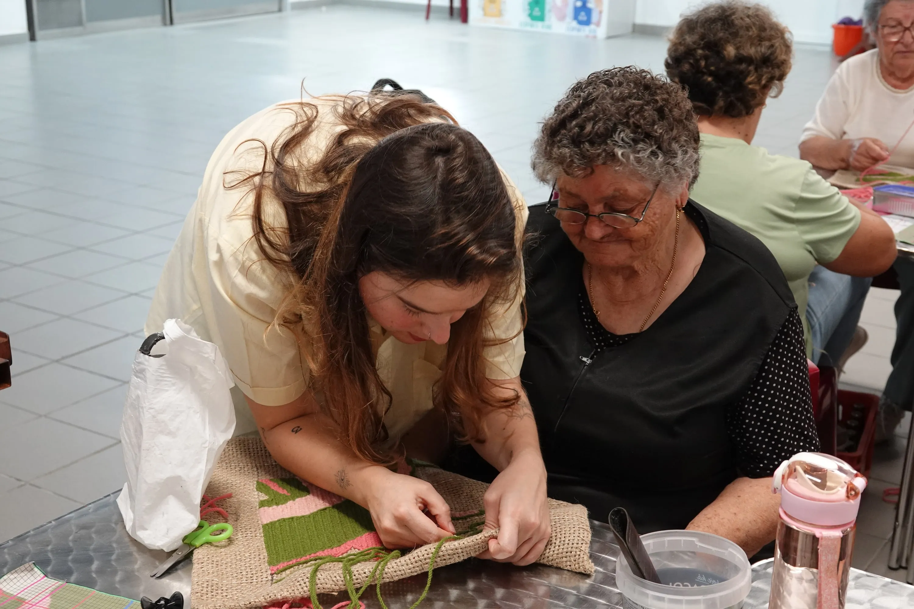 Collaborative guidance during the embroidery process at PONTO E TRAMA.