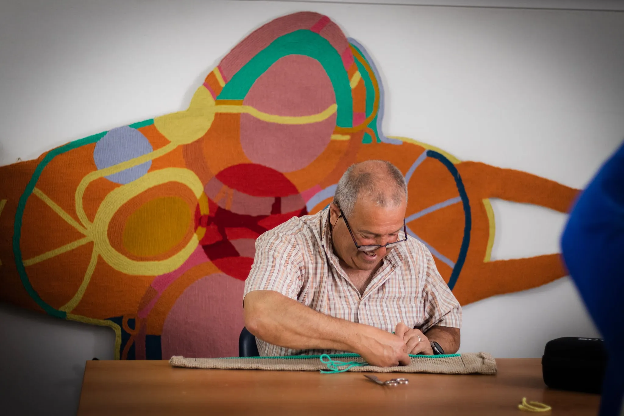 Participante a trabalhar num módulo têxtil em ponto de Arraiolos no atelier.