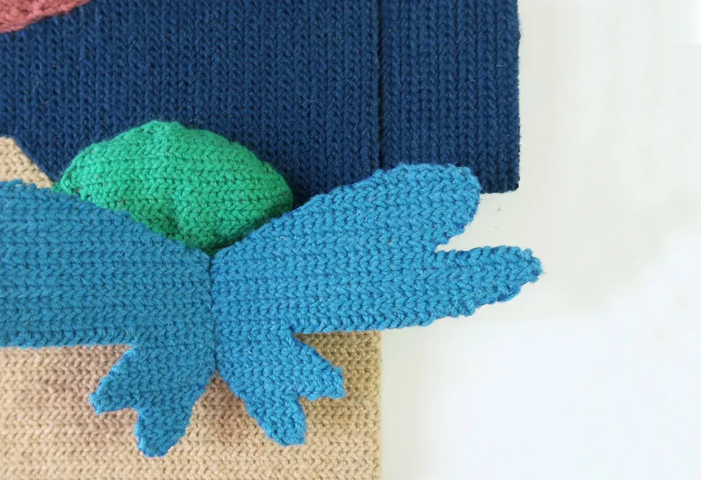 Detail of MIND GAME #1 showing the blue floral form over the green and navy textile elements.